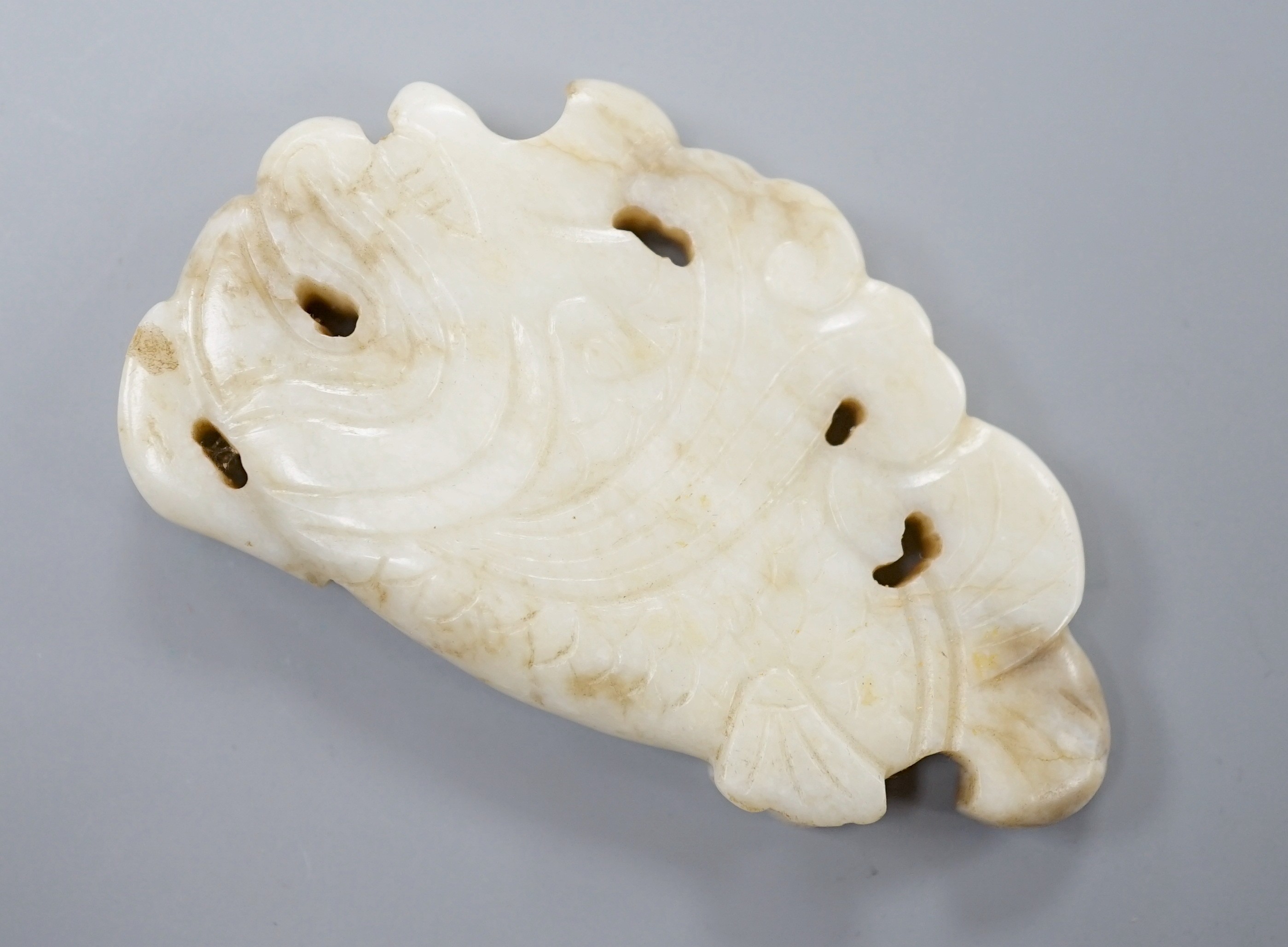 A Chinese white and black jade ‘dragon-fish’ plaque, 19th/20th century, 6cm